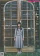 A woman standing in front of an old wooden door.