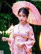 A woman in a pink kimono holding an umbrella.