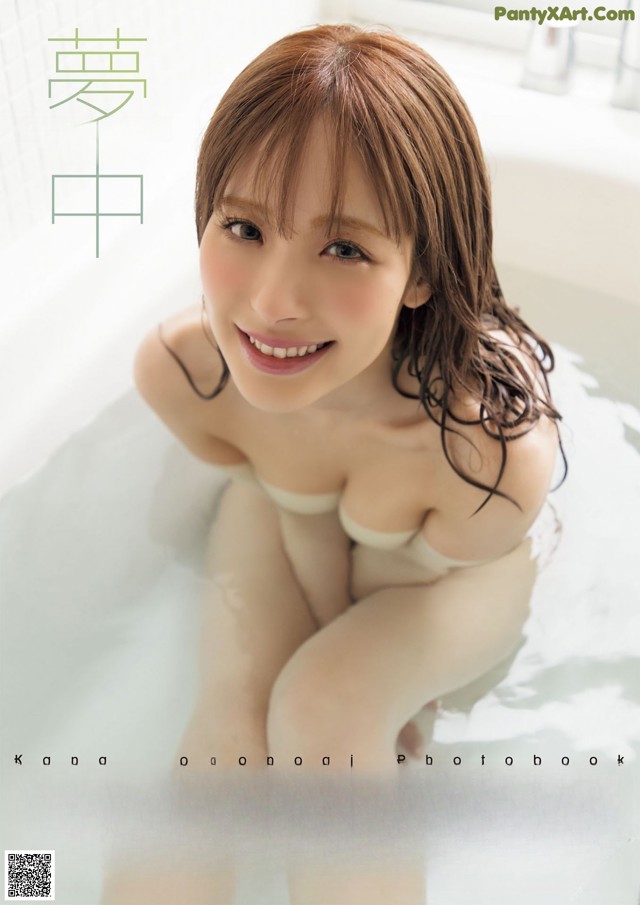 A woman sitting in a bathtub with a smile on her face.