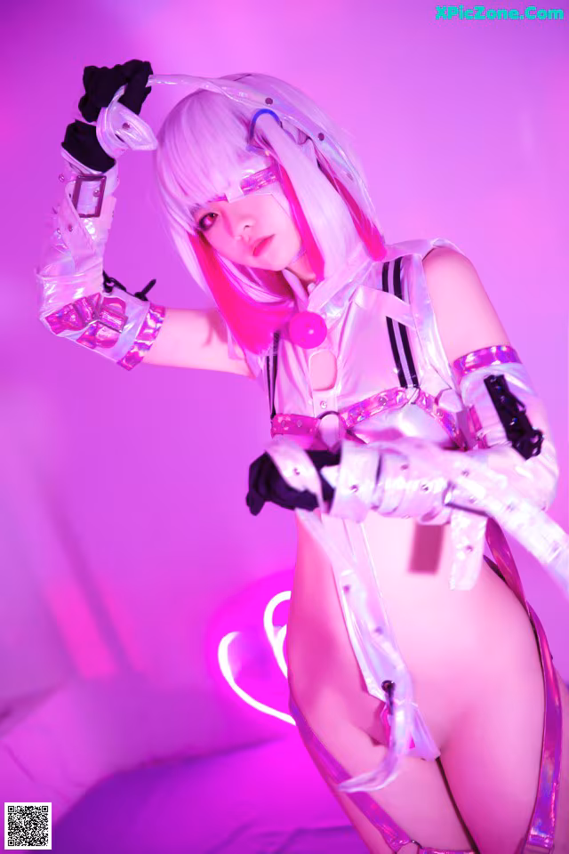 A woman in a white and pink outfit posing for a picture.