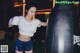 A woman wearing boxing gloves standing next to a punching bag.