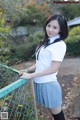 A woman in a school uniform posing for a picture.