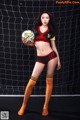 A woman in a soccer uniform holding a soccer ball.