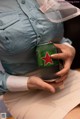 A woman holding a can of beer in her hands.