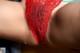 A close up of a woman's butt in a red lace panties.