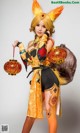 A woman dressed in a fox costume holding a lantern.