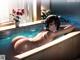 A woman in a bathtub with headphones on.