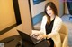 A woman sitting at a table using a laptop computer.