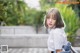 A little girl sitting on a bench in a park.