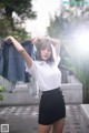 A woman in a white shirt and black skirt posing for a picture.