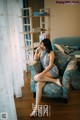 A woman sitting on a blue chair in a living room.