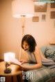 A woman sitting on a couch reading a book.