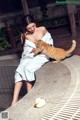 A woman sitting on a bench holding a cat.