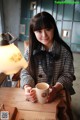 A woman sitting at a table with a cup of coffee.