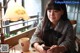 A woman sitting at a table with a cup of coffee and a cell phone.