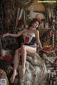 A woman sitting on a couch in a room decorated for Christmas.