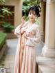 A woman in a pink kimono posing for a picture.