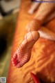 A close up of a woman's foot in a red fishnet stockings.