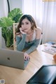 A woman sitting at a table with a laptop computer.