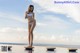 A woman in a white bikini standing on a dock.