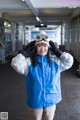 A woman in a blue jacket and goggles posing for a picture.