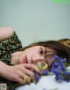 A woman laying on a bed with a bunch of flowers.