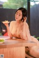 A woman sitting at a table with a plate of food.