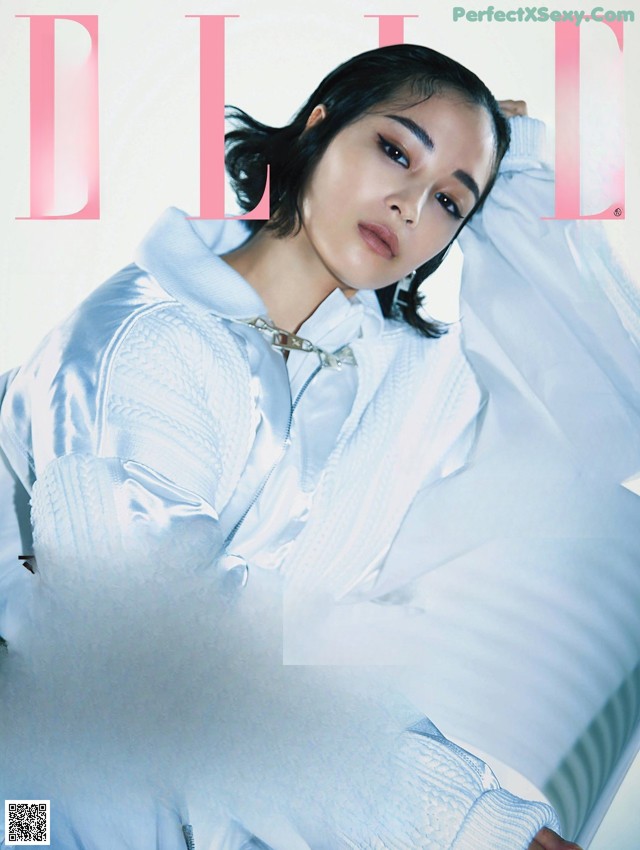 A woman laying on top of a bed on a magazine cover.