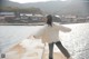 A woman standing on a pier near a body of water.