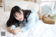 A woman laying on a bed reading a book.