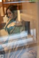 A woman sitting on a couch looking out a window.