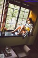 A woman in a kimono sitting on a window sill.