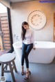 A woman sitting in a bathtub in a bathroom.