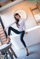 A woman sitting on top of a bathtub in a bathroom.