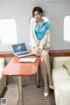 A woman sitting at a table with a laptop computer.