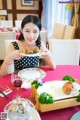 A woman sitting at a table with a plate of food.