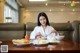 A woman sitting at a table with plates of food.