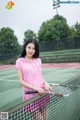 A woman holding a tennis racket on a tennis court.