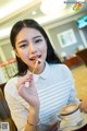 A woman sitting at a table eating a piece of cake.