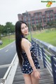 A woman in a bathing suit posing on a bridge.